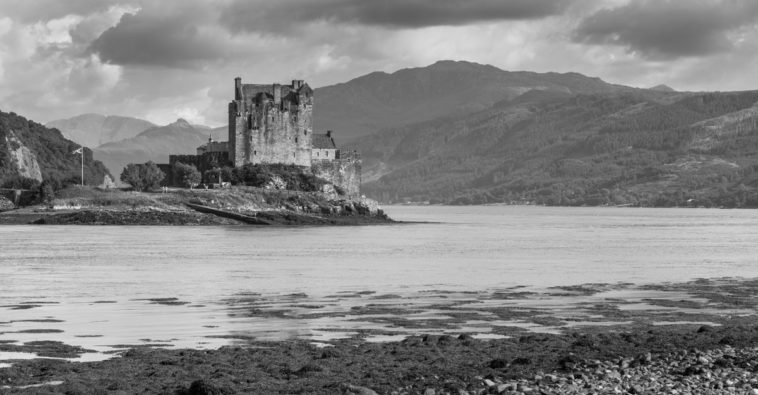 Photo en Noir et Blanc effectuée par Sarkis Ohanessian. Elle représente un château d'Écosse entouré d'un loch.