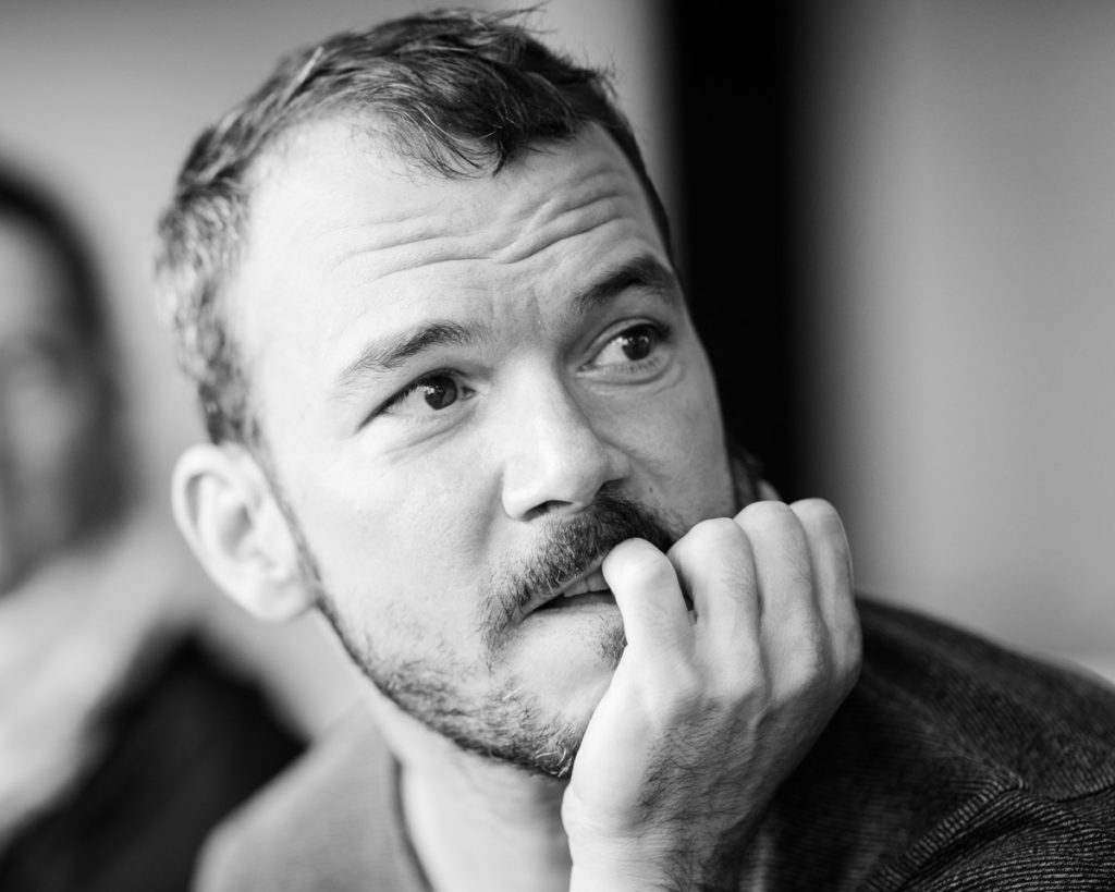 Sarkis a l'air stressé sur cette photo en noir et blanc prise avant le spectacle improvisé intitulé "dans le décor de". Il regarde sur la droit et mordille son petit doigt.