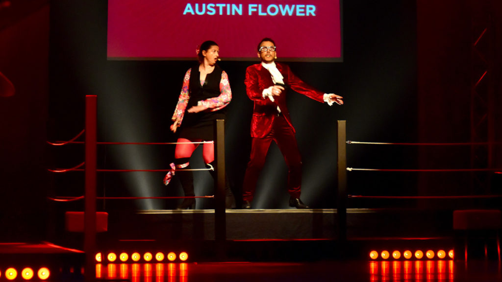 Sarkis Ohanessian et Julie Despriet sont sur le ring du Casino Théâtre à l'occasion du Mondial de Catch Impro. Ils représentent la Suisse avec comme équipe "Austin Flowers". Sarkis Est habillé en costume rouge et chemise à jabot.