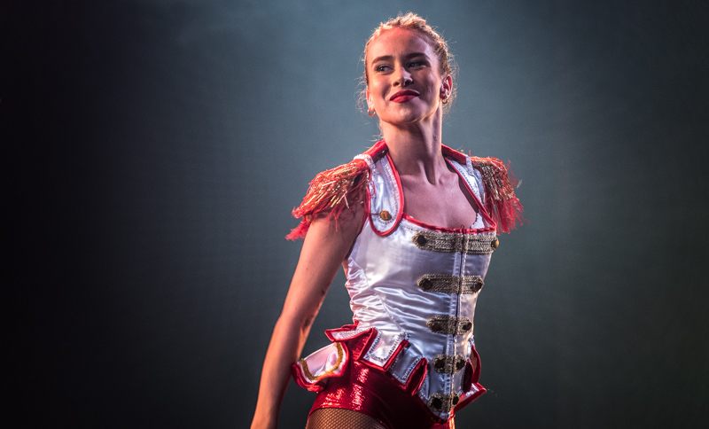 Clarissa Crivelli, danseuse de la Grande Revue Improvisée de Servion, se trouve, toute souriante, dans une belle lumière.