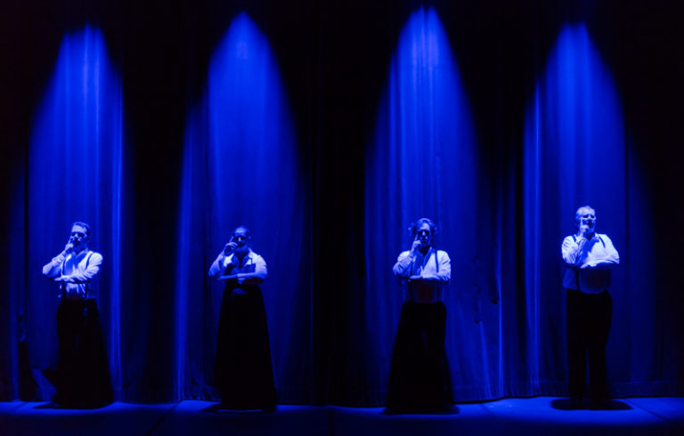 Les quatre Souffleurs aux Gradins, Sarkis Ohanessian, Julie Despriet, Axel van Exter et Jean-Claude Dubiez, sont en position de réflexion. Sous une lumière bleue en douche, ils ont une main contre le visage et l'autre bras à l'horizontale.