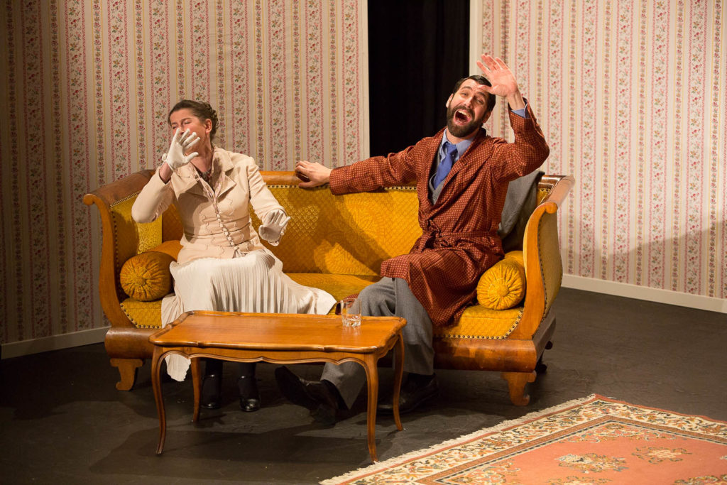 Julie Despriet et Christian Baumann, partenaire de scène de Sarkis Ohanessian, sont sur un canapé en train de rire. Ils interprètent la pièce "Thé à la menthe ou t'es citron" de Patrick Haudecoeur au Théâtre Le Caveau.