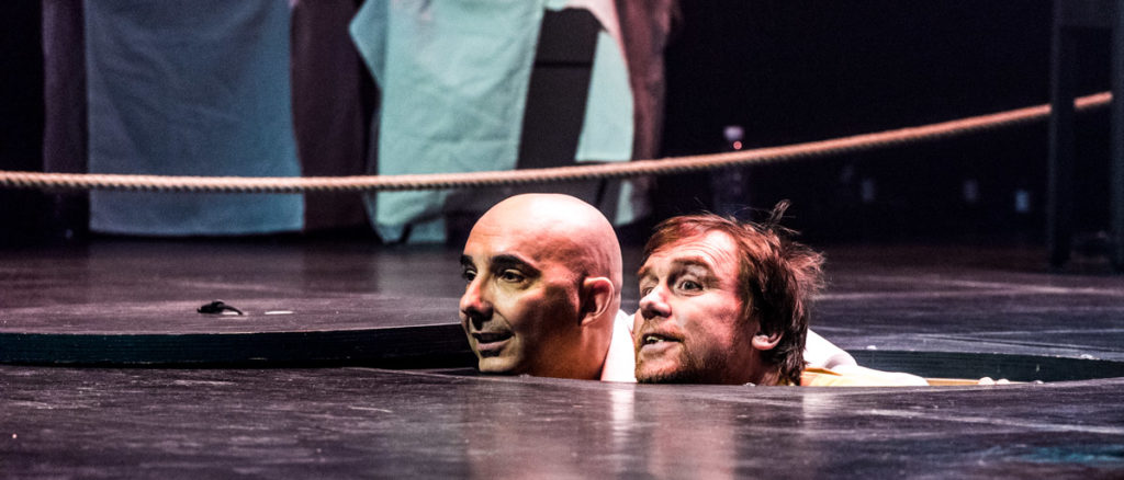 Axel van Exter et Carlos Henriquez passent leur tête par la trappe de la scène du Théâtre du pAssage à Neuchâtel durant la Coupe du Monde d'Impro Catch