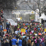 Photo de départ de la Course de l'Escalade à Genève. Il y a une foule de gens, habillés en habits de sport.