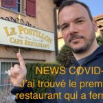 Selfie de Sarkis Ohanessian, habillé d'un sweat à capuche noir. Sarkis Ohanessian montre l'enseigne d'un café-restaurant qui s'appelle "Le Postillon". Sur la photo, il est écrit en orange en surimpression "News-Covid-19: j'ai trouvé le premier restaurant qui a fermé!"