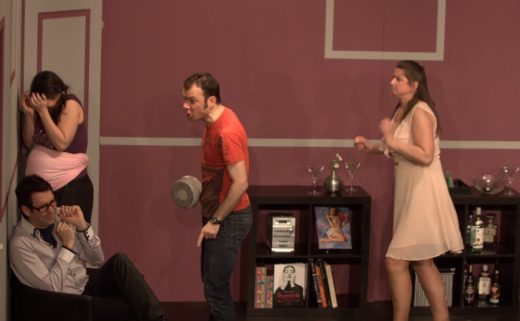 Sarkis Ohanessian est sur la scène du Théâtre le Caveau dans la pièce "Gros mensonges" de Luc Chaumar. Il est avec Estelle Zweifel, Christian Baumann et Julie Despriet. Il est vêtu d'un jeans noir et d'un t-shirt rouge.