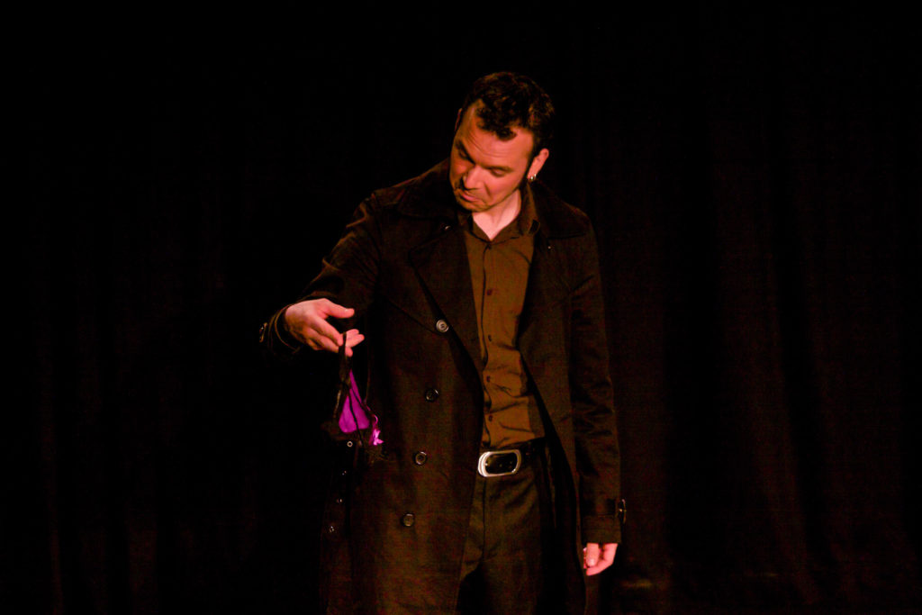 Sarkis Ohanessian, dans les Rogers de Jean Marc Dalpé, Robert Bellefeuille et Robert Marinier, est en jeans, chemise et manteau noir. Il tient un string à la main et le regarde, admiratif.