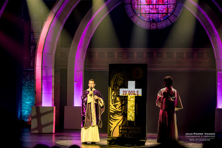 Sarkis Ohanessian, sur la scène du Théâtre Barnabé de Servion, joue Monseigneur O'hara. Il est vêtu d'une soutane banche avec une sorte de drapé violet à paillettes. A côté de lui, un compteur affiche 20 milles dollars.